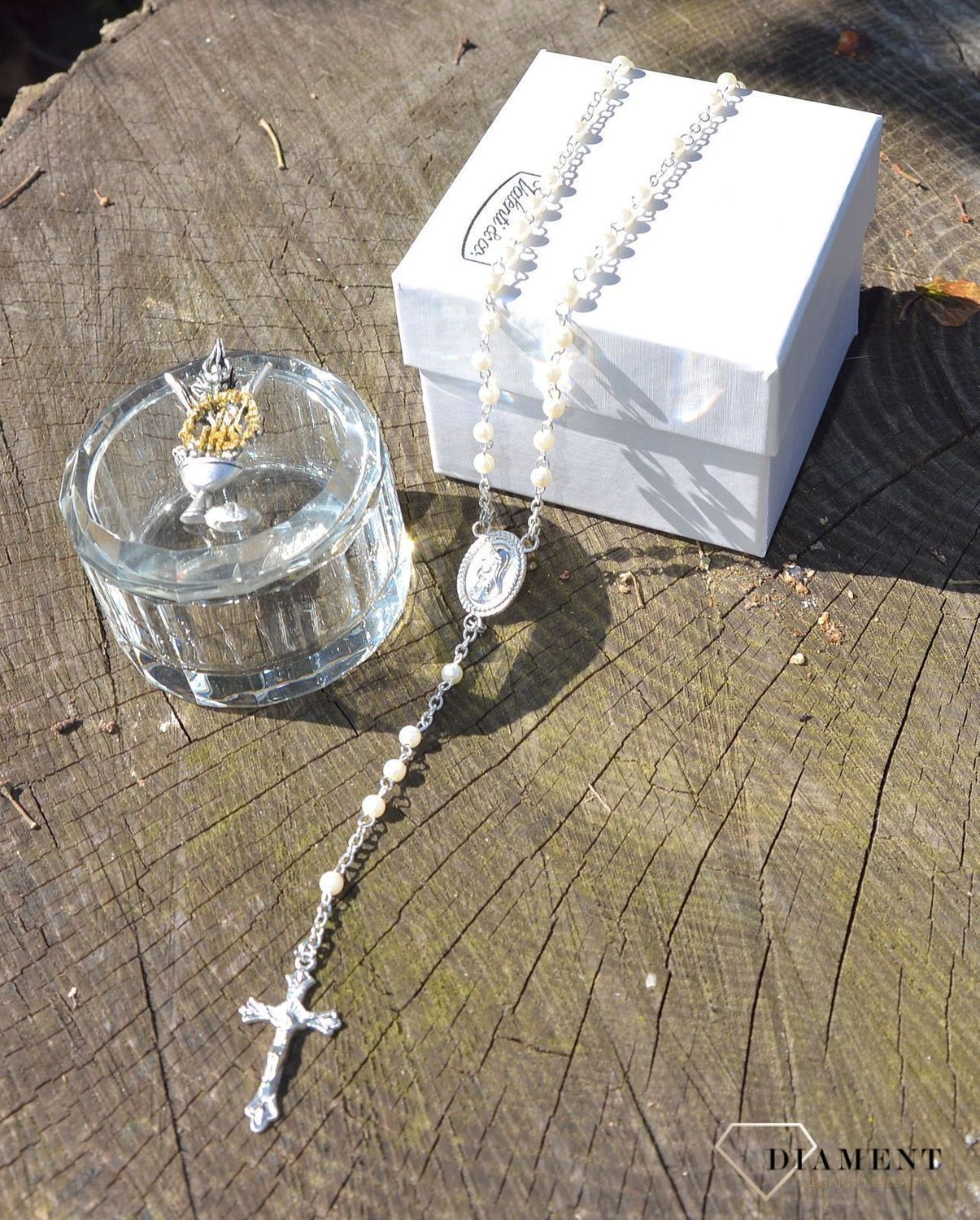 Różaniec komunijny z koralików w kolorze perłowym. Umieszczony w pięknie zdobionym szklanym opakowaniu. Na pokrywce starannie wykonany symbol komunijny - Hostia (1).JPG